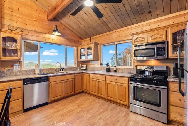 a kitchen with stainless steel appliances granite countertop wooden cabinets a stove top oven a sink and dishwasher