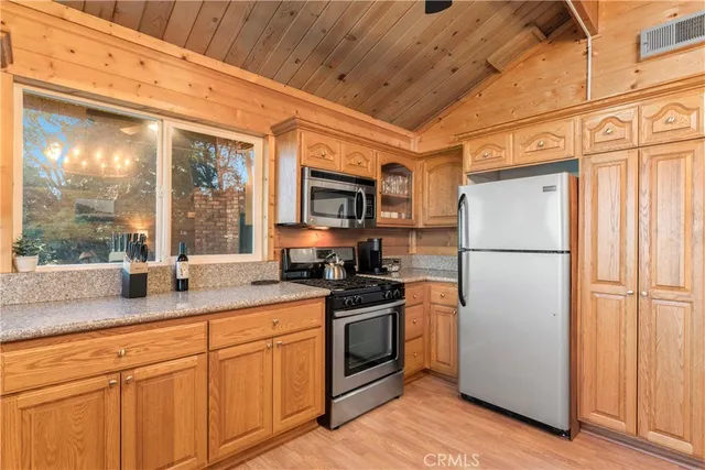 a kitchen with stainless steel appliances granite countertop a refrigerator a stove a sink dishwasher and a microwave oven with cabinets