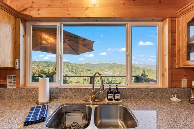 a kitchen with a sink a counter top space and living room filled with furniture