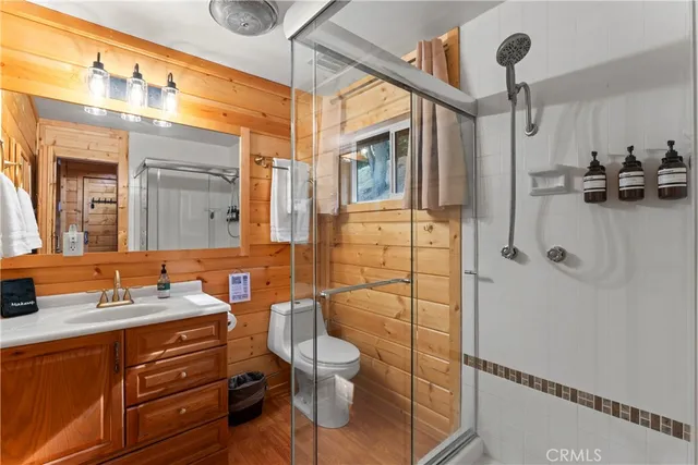 a bathroom with a granite countertop sink a mirror and shower