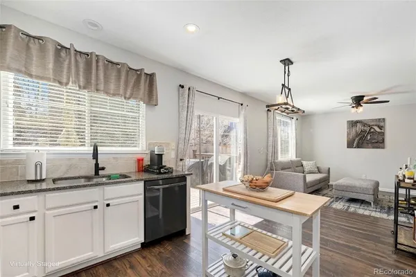 a kitchen with granite countertop a sink a window cabinets and stainless steel appliances