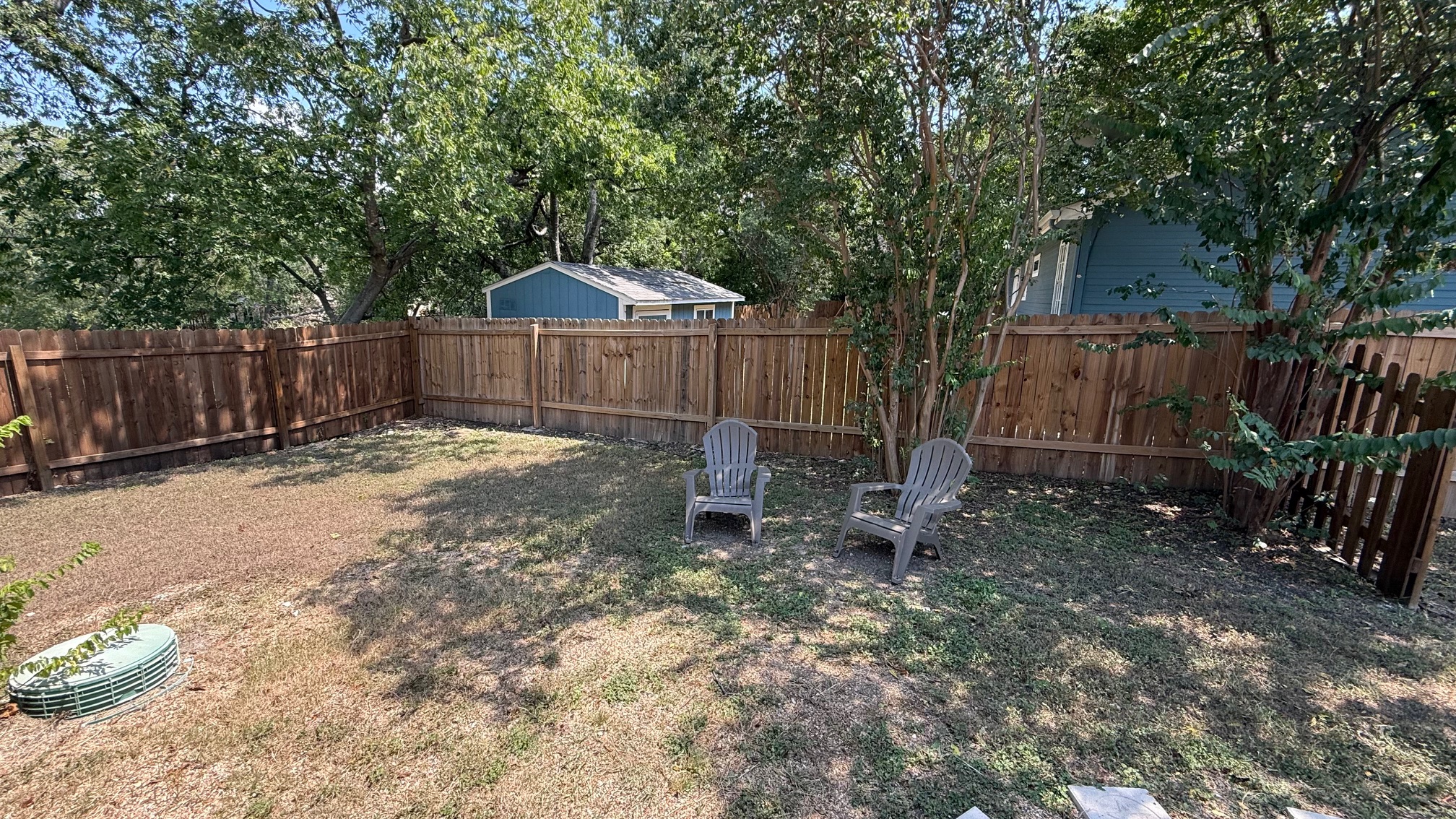 1802 East University Avenue Georgetown, TX 78626 - Photo 5 of 35 a view of a backyard with a small cabin and a chair