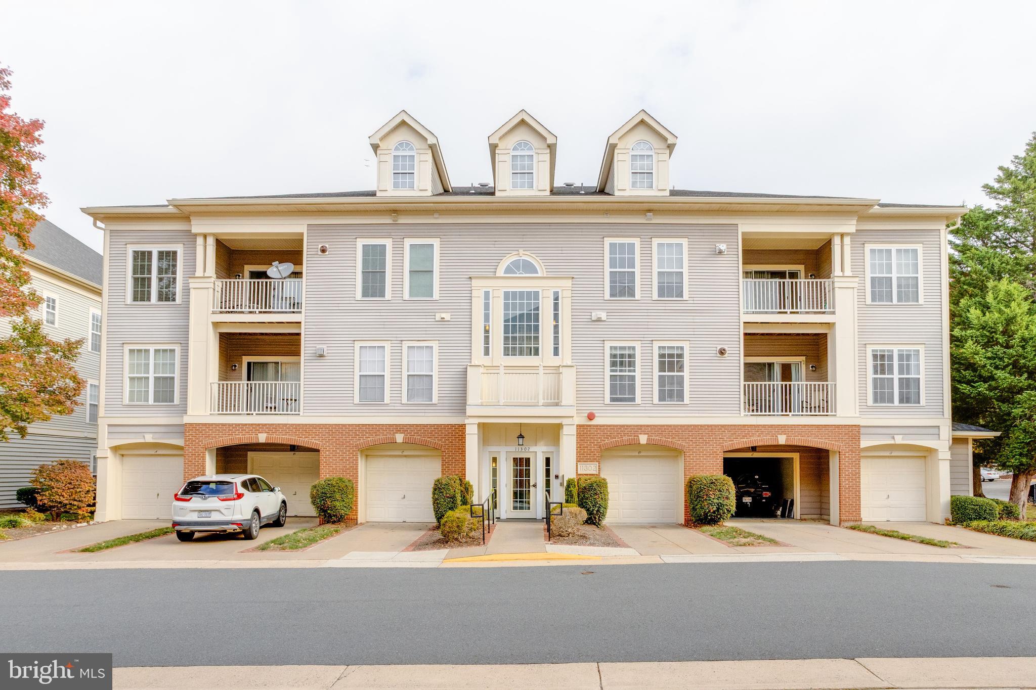 11302 Westbrook Mill Lane, Unit 204 Fairfax, VA 22030 - Photo 1 of 30 a front view of a building with lot of cars and brick wall