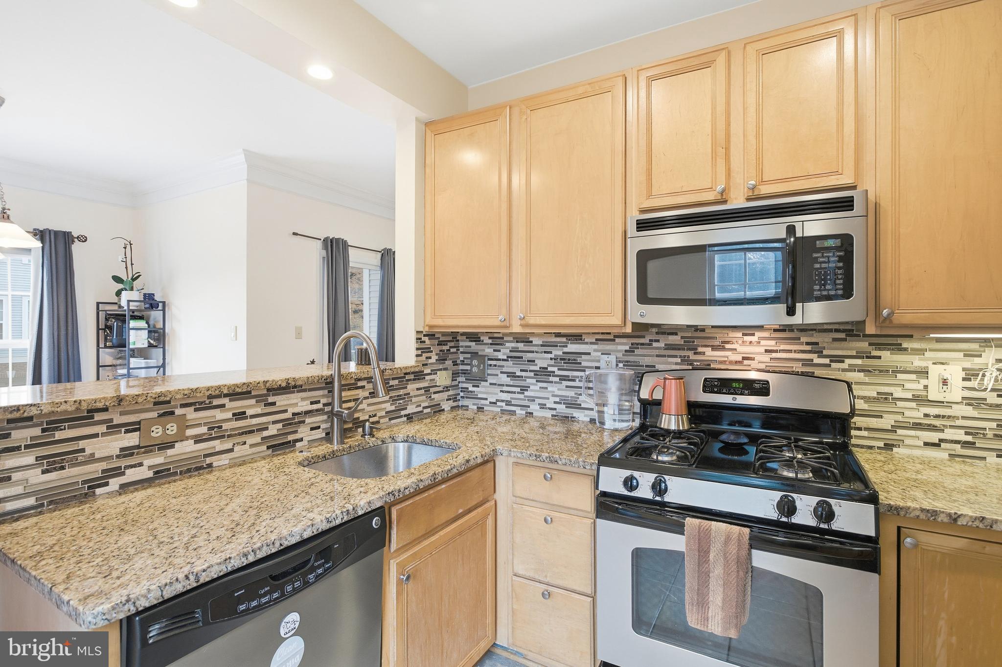 11302 Westbrook Mill Lane, Unit 204 Fairfax, VA 22030 - Photo 12 of 30 a kitchen with stainless steel appliances granite countertop a stove microwave and cabinets