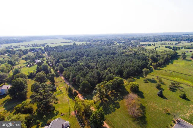 an aerial view of a houses with a lush green hillside