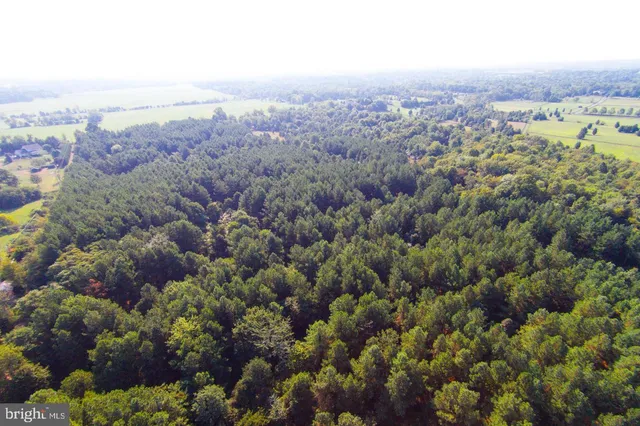 an aerial view of house with yard and mountain view in back