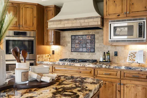 a kitchen with stainless steel appliances kitchen island granite countertop a refrigerator and microwave