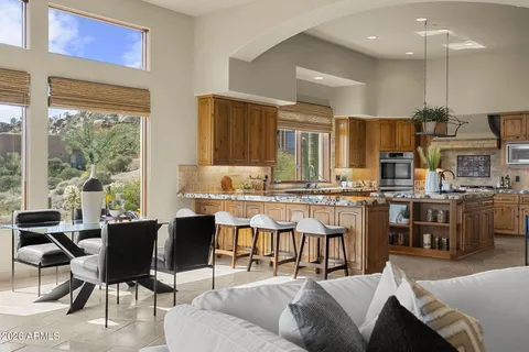 a living room with fireplace furniture large window and wooden floor
