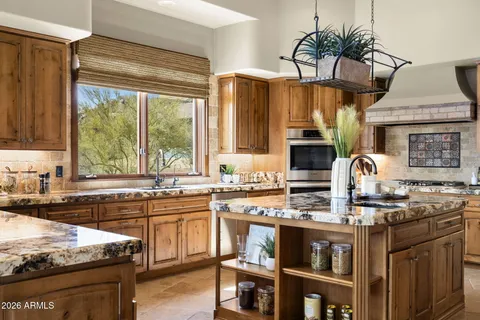 a living room with stainless steel appliances kitchen island granite countertop furniture and a large window