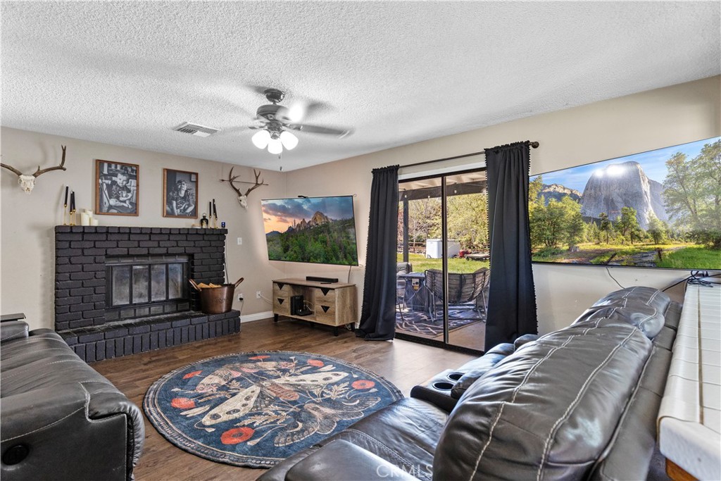 21921 Fig Court Tehachapi, CA 93561 - Photo 11 of 44 a living room with furniture a fireplace and a floor to ceiling window
