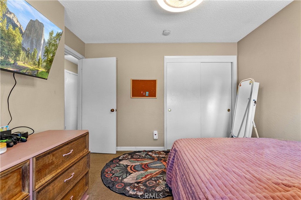 21921 Fig Court Tehachapi, CA 93561 - Photo 25 of 44 a bedroom with a bed and a mirror