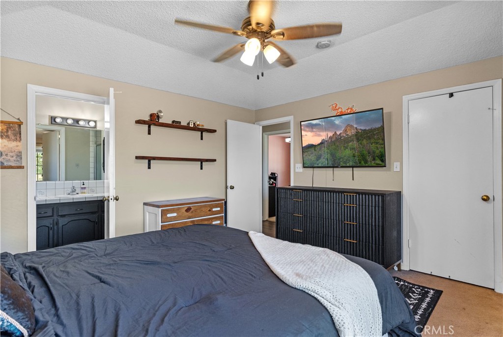 21921 Fig Court Tehachapi, CA 93561 - Photo 28 of 44 a bedroom with a bed and a flat tv screen on dresser