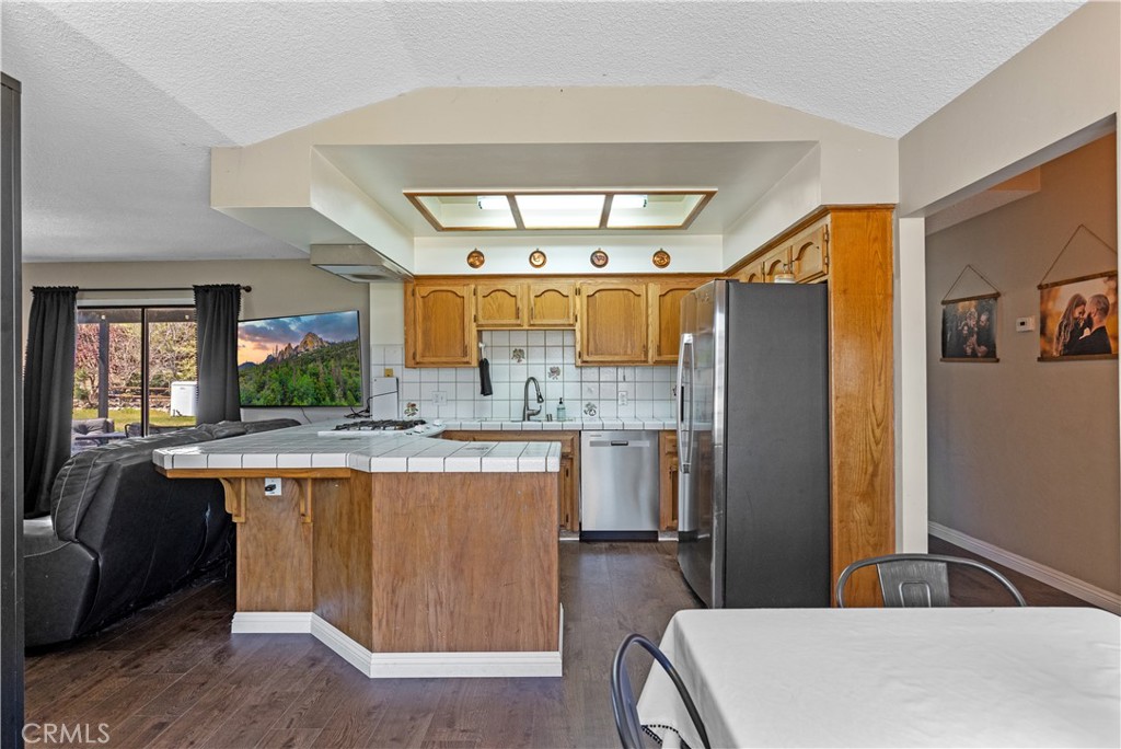 21921 Fig Court Tehachapi, CA 93561 - Photo 7 of 44 a kitchen with stainless steel appliances a sink stove and refrigerator