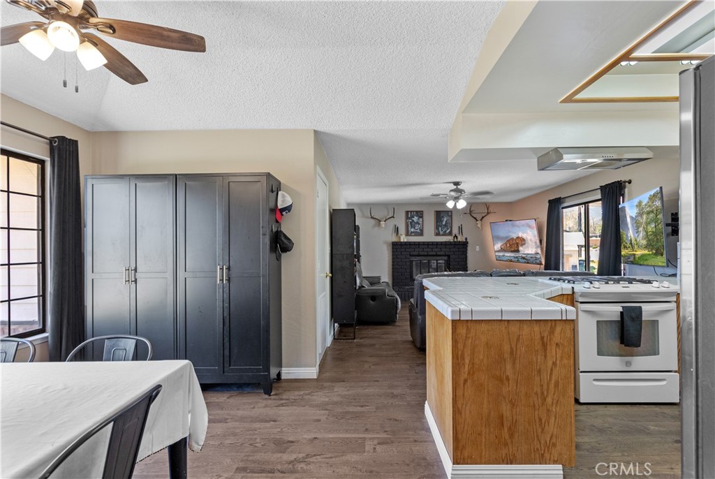 21921 Fig Court Tehachapi, CA 93561 - Photo 10 of 44 a kitchen with kitchen island a stove a counter space a sink and a refrigerator