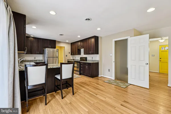 a kitchen with kitchen island granite countertop wooden cabinets a refrigerator a stove a sink and a oven