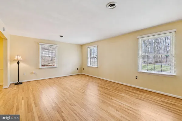 a view of empty room with wooden floor and fireplace