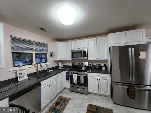 a kitchen with a sink stainless steel appliances and cabinets