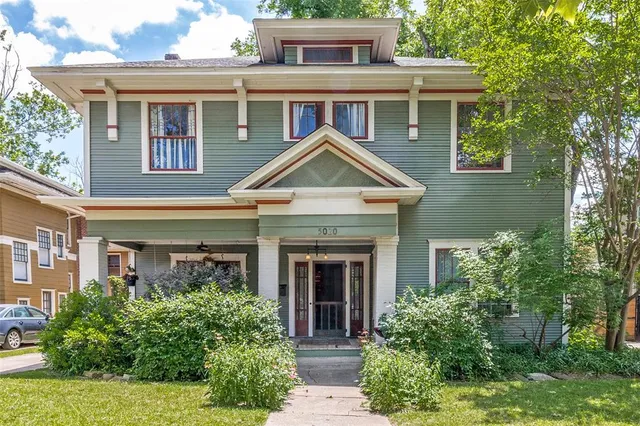 a front view of a house with plants and garden