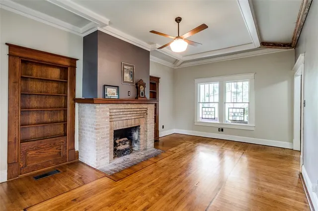 a view of an empty room with a fireplace and a window