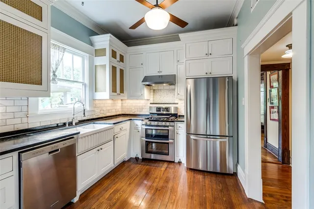 a kitchen with stainless steel appliances a refrigerator sink and cabinets