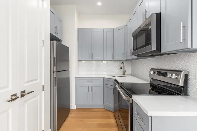 a kitchen with stainless steel appliances a sink a stove a microwave and cabinets