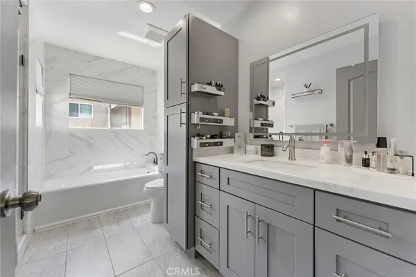 a bathroom with a sink double vanity granite tub shower and a mirror