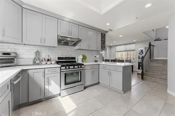 a kitchen with white cabinets and appliances