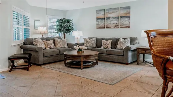 a living room with furniture a flat screen tv and floor to ceiling window