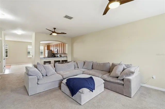 a living room with furniture and a view of kitchen