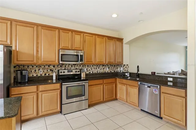 a kitchen with stainless steel appliances granite countertop a stove a sink and a microwave
