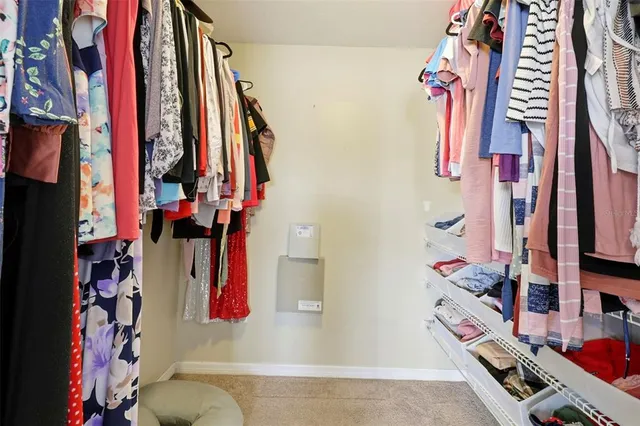 a view of walk in closet with clothes and shoes