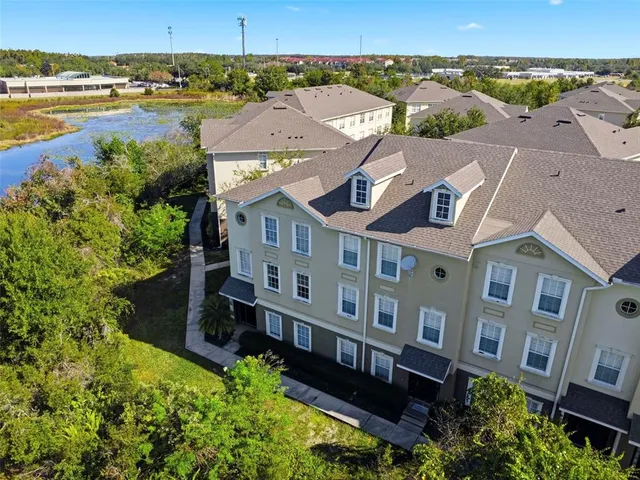 an aerial view of a house with a big yard plants and large tree
