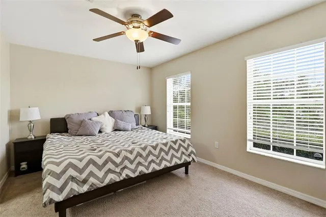 a bedroom with a bed ceiling fan and a window