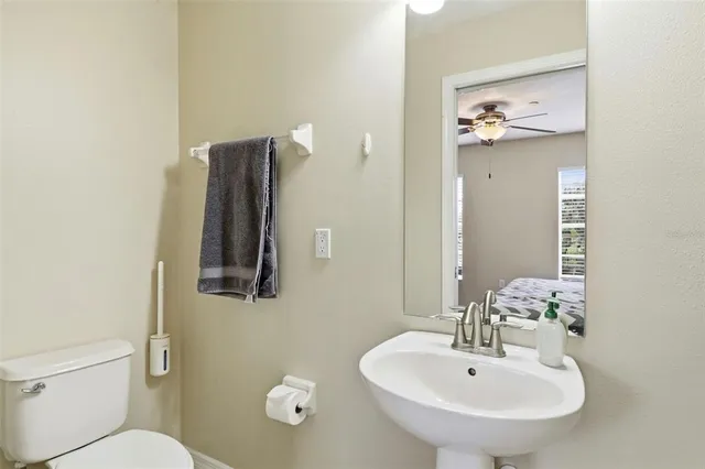 a bathroom with a sink and mirror with toilet