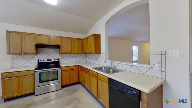 a kitchen with stainless steel appliances a sink stove and cabinets