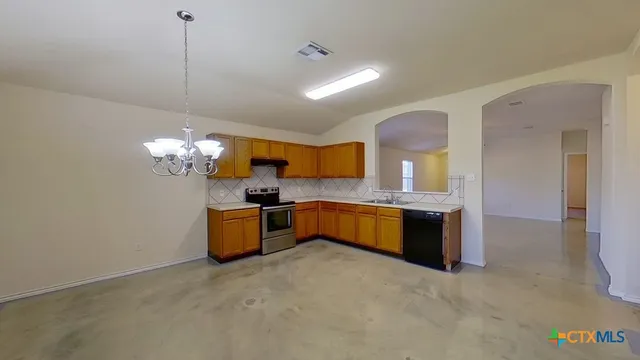 a large kitchen with a sink and chandelier