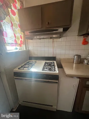 a stove top oven sitting inside of a kitchen