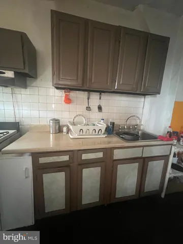 a view with granite countertop a sink a stove and cabinets