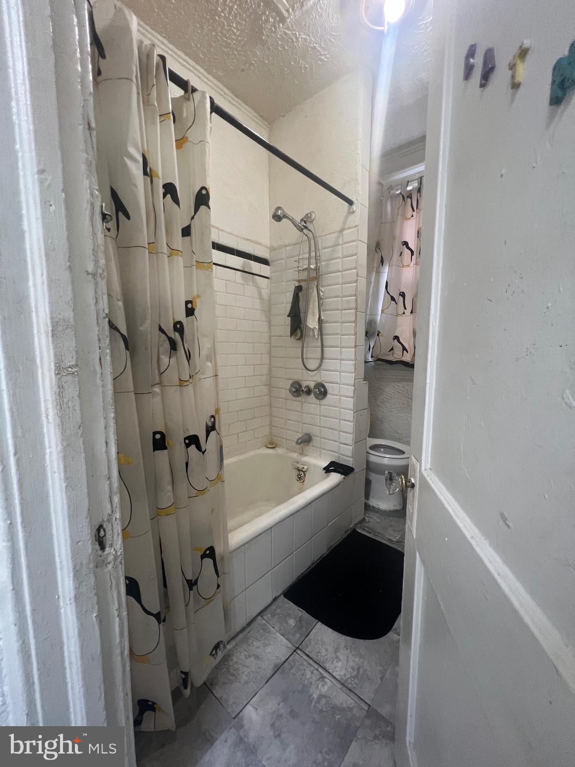 4506 Reisterstown Road Baltimore, MD 21215 - Photo 7 of 22 a bathroom with a bathtub a toilet and a shower