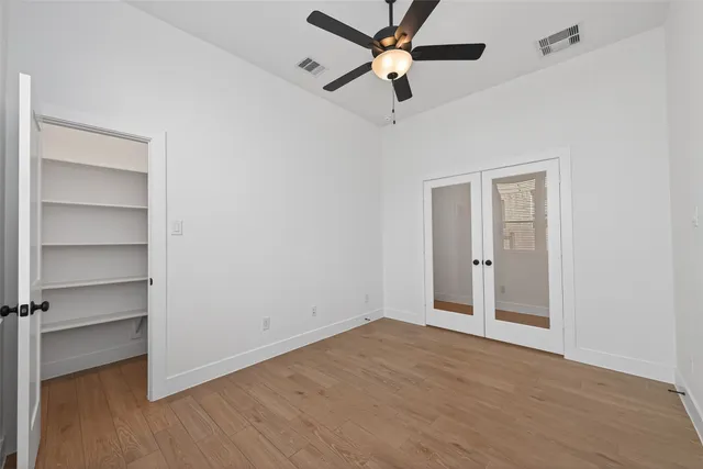 an empty room with a ceiling fan and a window