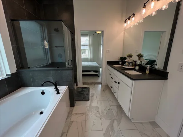 a en suite spacious bathroom with a double vanity sink and a bathtub