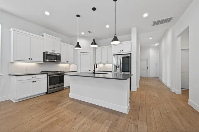 a view of a hallway with wooden floor and staircase