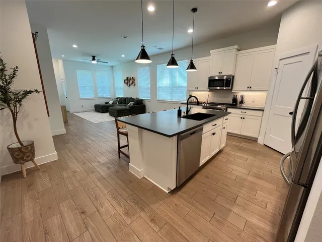 a kitchen with stainless steel appliances granite countertop a sink stove and refrigerator