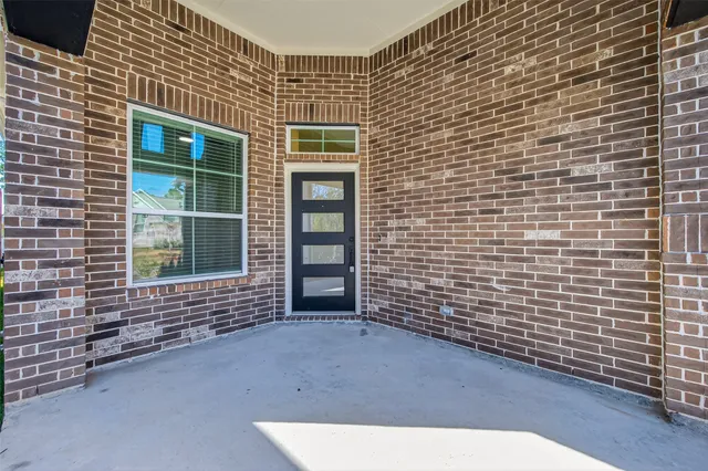 a living room with stainless steel appliances furniture wooden floor and a kitchen view