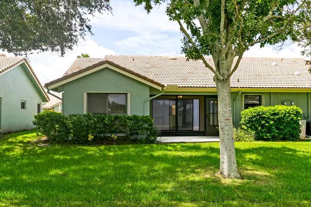 a front view of a house with a yard and potted plants