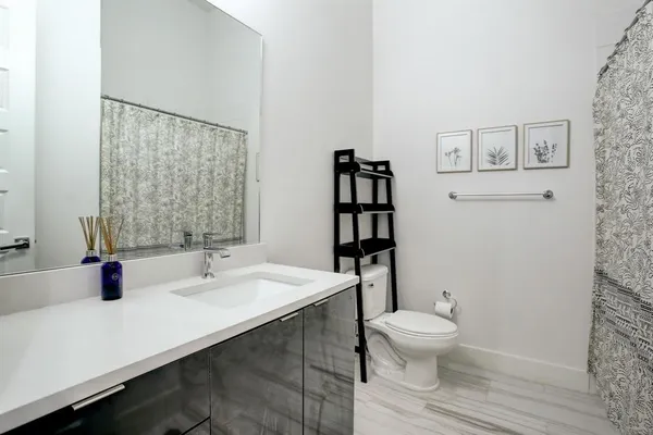 a bathroom with a sink a toilet and shower