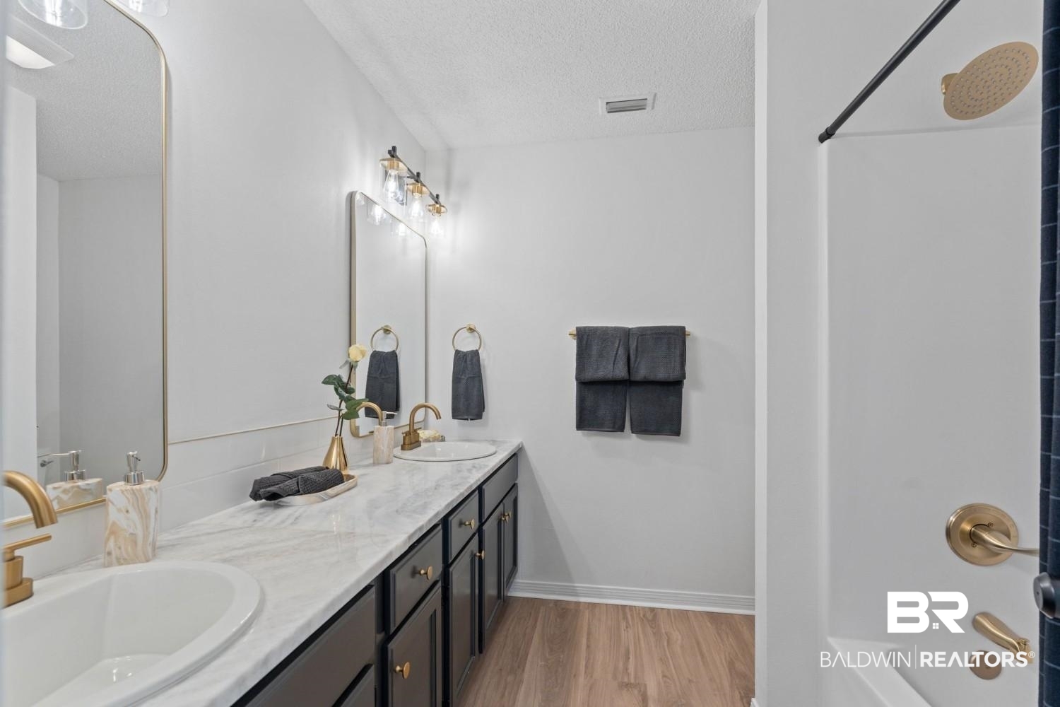 10251 Windmill Road Fairhope, AL 36532 - Photo 35 of 44 Full bath with a textured ceiling, double vanity, wood finished floors, and bathtub / shower combination