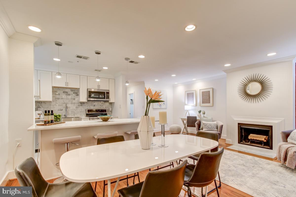 a kitchen with stainless steel appliances a dining table chairs and microwave