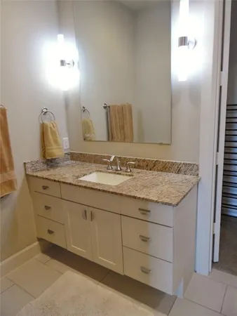 a bathroom with a granite countertop sink and a mirror