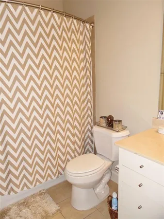 a white toilet sitting next to a shower curtain